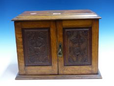 AN OAK WALL MOUNTING SMOKERS CABINET PRESENTED IN 1911 TO F SCHOLES, THE INTERIOR OF THE DOORS