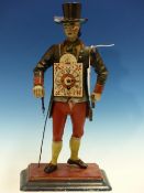 A CLOCK VENDOR FIGURAL CLOCK, HE STANDS WEARING RED BRITCHES, BLUE JACKET AND BLACK TOP HAT. H