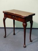 A GEORGIAN WALNUT TEA TABLE, THE CONCAVE FRONT WITH SHAPED CORNERS AND OPENING ON SINGLE GATE, THE