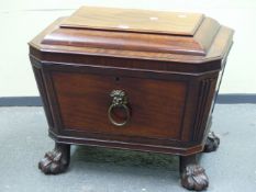 A REGENCY MAHOGANY SARCOPHAGUS SHAPED WINE COOLER, THE HINGED LID OPENING ONTO A METAL LINER, THE