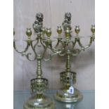 A PAIR OF BRASS FOUR LIGHT CANDELBRA, THE NOZZLES CENTRED BY A LION HOLDING THE ARMORIAL SHIELD OF