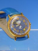 A VINTAGE MANUAL WOUND SNOOPY WRIST WATCH FEATURING SNOOPY PLAYING TENNIS WITH A TENNIS BALL