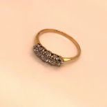 A YELLOW METAL FIVE STONE DIAMOND GRADUATED CLAW SET RING, FINGER SIZE P, GROSS WEIGHT 2.0grms.