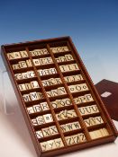 A 19TH. CENTURY BONE SPELLING ALPHABET CONTAINED WITHIN MAHOGANY SLIDE TOP BOX. APPROX 174 DOUBLE