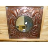 A SQUARE FRAMED COPPER CIRCULAR MIRROR, THE FRAME WORKED WITH A BIRD AMONGST FOLIAGE ON A MARTELE