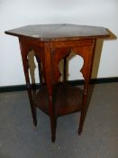 AN ARTS AND CRAFTS OAK HEXAGONAL TWO TIER TABLE, THE OGEE ARCH APRON JOINING CYLINDRICAL LEGS