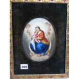 A FRAMED OVAL PORCELAIN PLAQUE PAINTED WITH THE MADONNA WITH THE CHRIST CHILD ON HER LAP AS SHE SITS