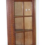 AN EARLY 20th.C.OAK FLOOR STANDING CORNER CABINET WITH CARVED DECORATION, SIX PANE GLAZED UPPER OVER