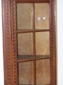 AN EARLY 20th.C.OAK FLOOR STANDING CORNER CABINET WITH CARVED DECORATION, SIX PANE GLAZED UPPER OVER