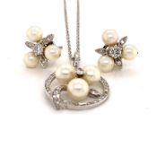 AN 18CT WHITE GOLD DIAMOND AND PEARL PENDANT AND EARRINGS SET. THE BRILLIANT CUT CENTRE DIAMOND