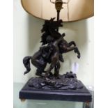 A SPELTER MARLEY HORSE SUPPORTED TABLE LAMP, THE RECTANGULAR PLINTH WITH FOUR BRASS BALL FEET. W