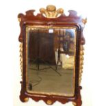 A GEORGIAN STYLE PARCEL GILT MAHOGANY FRAMED RECTANGULAR MIRROR, THE CUT WORK TOP CENTRED BY THE