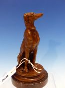 AFTER BARYE, A BRONZE FIGURE OF A GREYHOUND SEATED ON A CARPET ROUNDEL. H 17.5cms.
