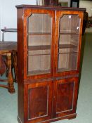 A MAHOGANY BOOK CASE, THE RECTANGULAR TOP OVER DOORS GLAZED WITH THREE PANELS OVER TWO ADJUSTABLE