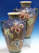 A PAIR OF SATSUMA BLUE GROUND TWO HANDLED OVOID VASES THICKLY ENAMELLED WITH IRISES. H 40cms.