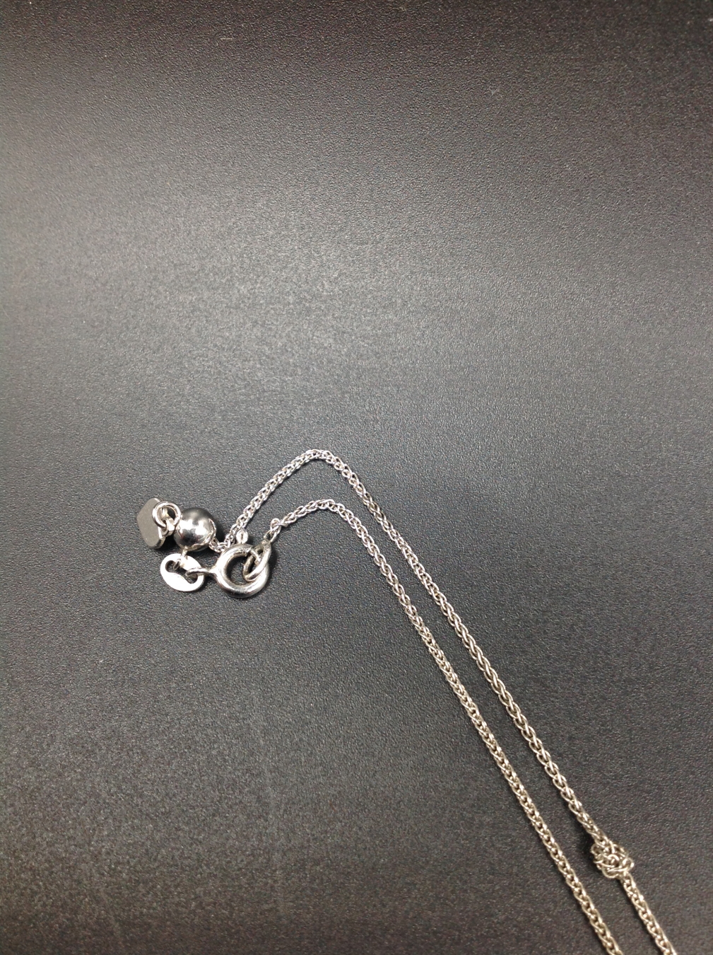 A SILVER HALLMARKED TIFFANY AND CO NOTES LETTER J DISC PENDANT COMPLETE WITH ADJUSTABLE CHAIN. - Image 5 of 5