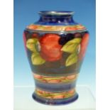 A MOORCROFT BLUE GROUND VASE SLIP TRAILED WITH A BAND OF RED POMEGRANATES, IMPRESSED MARKS AND