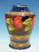 A MOORCROFT BLUE GROUND VASE SLIP TRAILED WITH A BAND OF RED POMEGRANATES, IMPRESSED MARKS AND