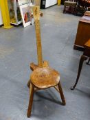 A GUITAR CHAIR, THE BLOND WOOD BACK SAWN WITH FRETS ABOVE A YEW WOOD SADDLE SEAT AND TURNED OAK