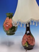A MOORCROFT AND A LAMP BASE SLIP TRAILED WITH ORANGE HIBISCUS, THE VASE WITH A GREEN GROUND. H19.