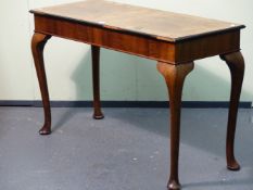 A WALNUT CONSOLE TABLE, THE CROSS BANDED RECTANGULAR TOP WITH EBONISED THUMBNAIL EDGE AND ON