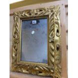 A RECTANGULAR MIRROR IN A BAROQUE STYLE GILT WOOD FRAME PIERCED AND CARVED WITH FOLIAGE. H 53 x 44.