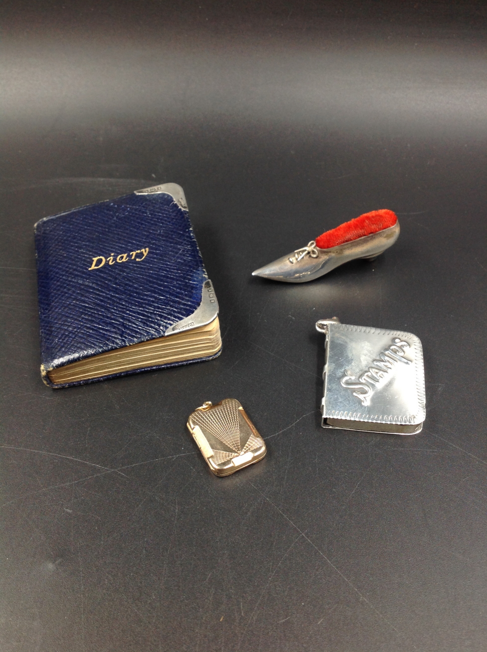 A SILVER HALLMARKED SHOE FORM PIN CUSHION, TOGETHER WITH A SILVER STAMP HOLDER, AND A WALKER'S