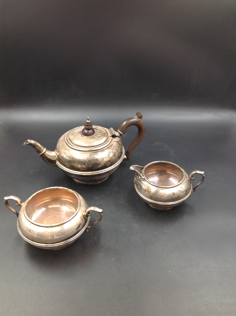 AN EDWARDIAN SILVER HALLMARKED THREE PART TEA SET COMPRISING OF TEA POT, SUGAR BOWL AND CREAMER.