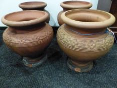 A PAIR OF HATHERN STATION CO. LTD. RED TERRACOTTA PLANTERS A CIRCULAR BAND OF FLOWER HEADS ON THE