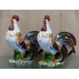 A PAIR OF COLOURFUL POTTERY CROWING COCKERELS. H 53cms.