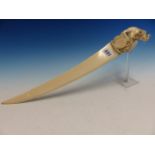 AN INDIAN IVORY PAGE TURNER WITH SCIMITAR BLADE, THE HANDLE CARVED WITH A LION ATTACKING AN