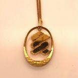 AN 18ct GOLD ARTICULATED PENDANT SUSPENDED ON AN 18ct GOLD 60cm CURB WITH ADDED SAFETY CHAIN.