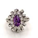 A PLATINUM AMETHYST AND DIAMOND CLUSTER RING. THE CENTRAL MARQUIS CUT AMETHYST SURROUNDED BY A