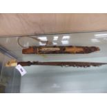 A DAYAK HEAD HUNTERS SWORD, THE WOODEN SCABBARD MOUNTED WITH BONE, THE SINGLE EDGED BLADE WITH