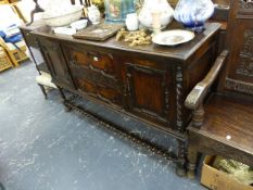 AN OAK SIDEBOARD WITH BARLEY TWIST STRETCHERS.