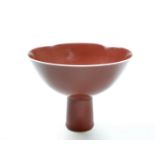 The stem cup is covered to the exterior and interior with a strawberry red glaze, stopping short