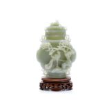 The finely carved jade "hu" lidded vase depicting pine trees and phoenix. Wood stand. Height: 18 cm,