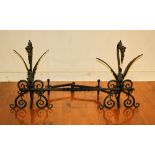 Pair of Gothic-style griffin-form wrought iron andirons with cross bar, 26 1/2" H, bar is 43 1/2" W.