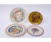 Group of four Poole plates variously decorated with the ZY pattern, a bouquet, deer and a fish