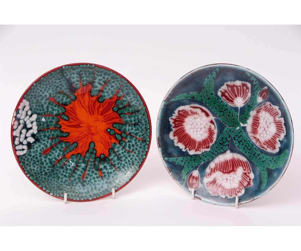 Two Poole plates, one with a floral design, the other an abstract design, both signed to the base by