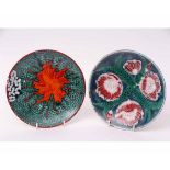 Two Poole plates, one with a floral design, the other an abstract design, both signed to the base by