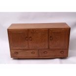 Ercol light elm sideboard, three doors over two drawers, 130cms wide
