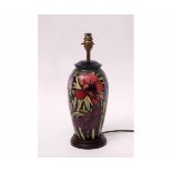 Moorcroft lamp base with a stylised tube lined design of anemones or hibiscus on a black oval