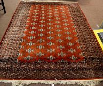 Modern Bokhara type carpet with rust ground and geometric repeating lozenge on a multi-gulled