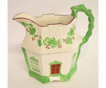 Pratt ware style pottery jug, the lobed sides modelled as a house with a green handle and brown
