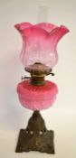 Large brass lamp, late 19th century, with pink glass reservoir and shade with floral decoration