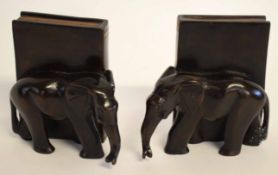 Pair of ebony book stands modelled as an elephant standing beside a book, 15cms tall