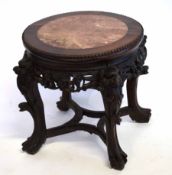 Chinese hardwood marble top plant stand on four heavily carved feet and an open work stretcher, with