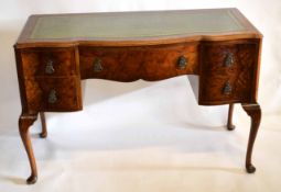 Early 20th century walnut shaped fronted five drawer desk with green leather and tooled insert,