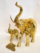 Large brass model of an elephant with raised trunk and damage to ear, together with a further